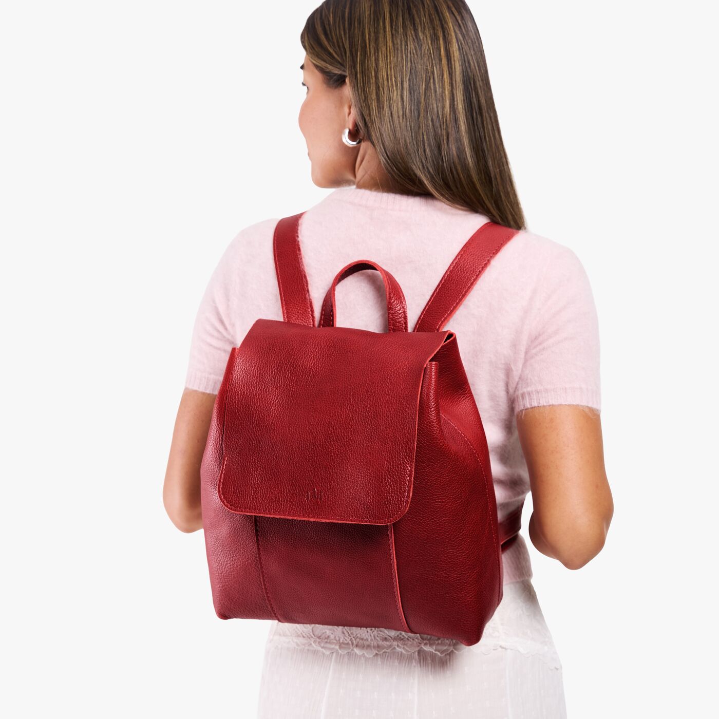 Chili Red | Model wearing a leather backpack on a white background