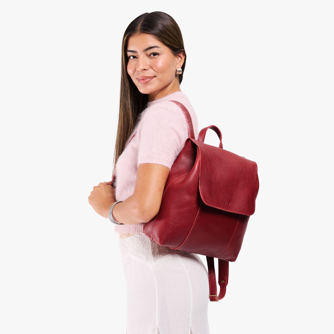 Chili Red | Model wearing a leather backpack on a white background