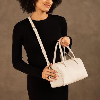 Pebbled Bone*Oversized | Model holding mini duffle shaped handbag with crossbody strap