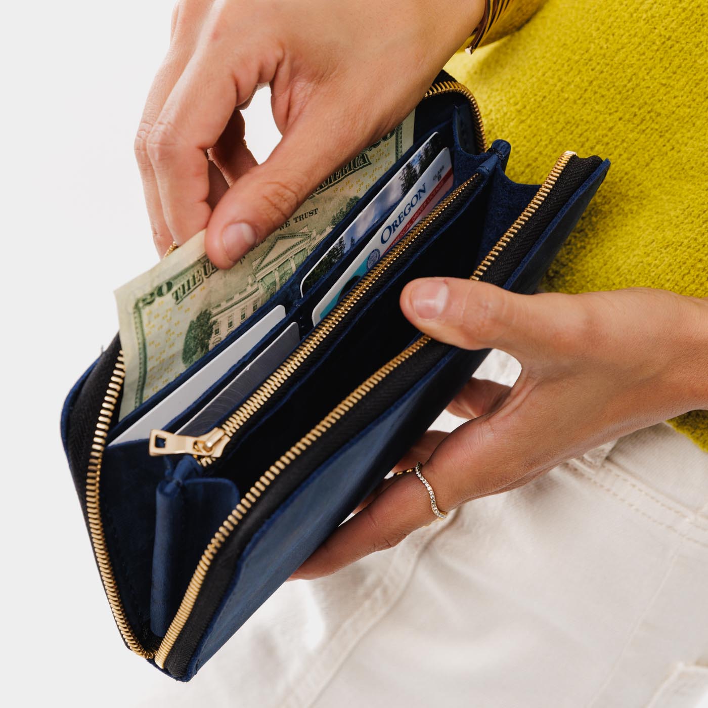Deep Water | Model holding large accordion leather wallet with zipper open