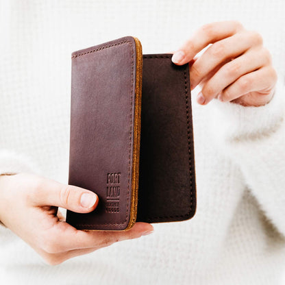 Cognac | Model holding leather passport case with PLG logo