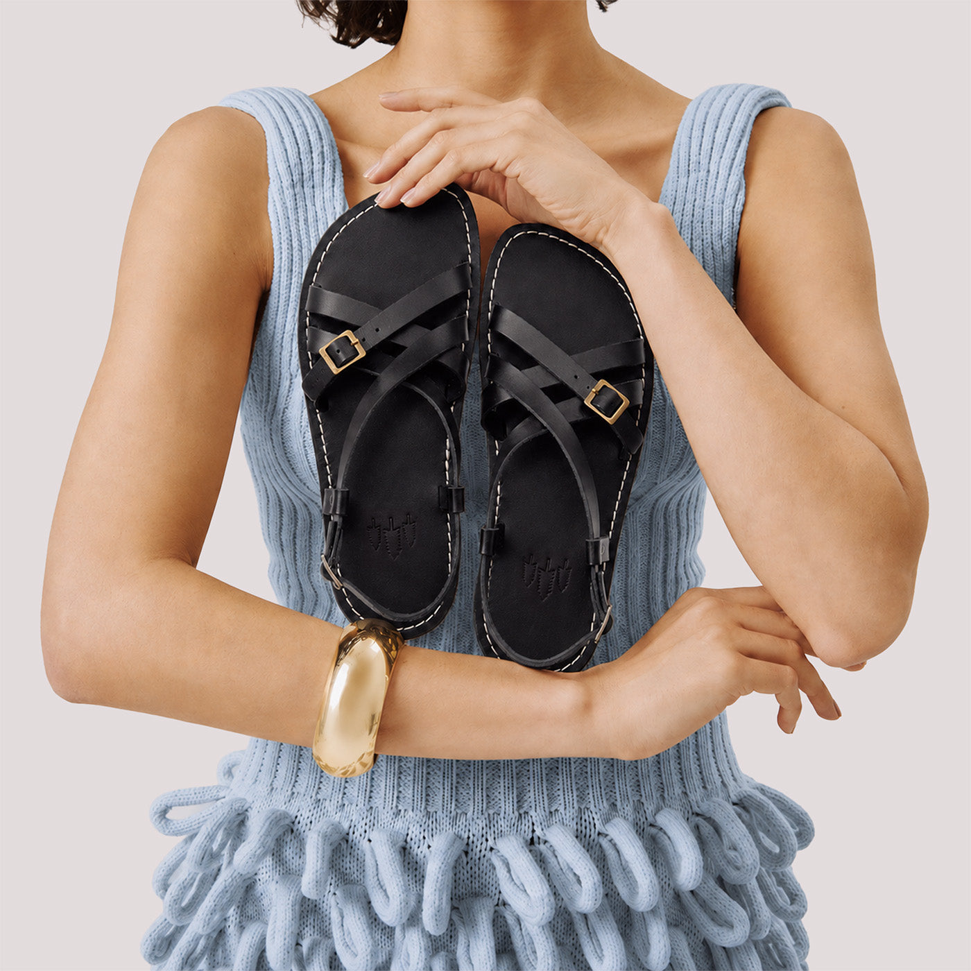 Nero | Person wearing strappy leather sandals with two buckle accents