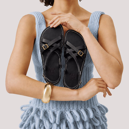 Nero | Person wearing strappy leather sandals with two buckle accents
