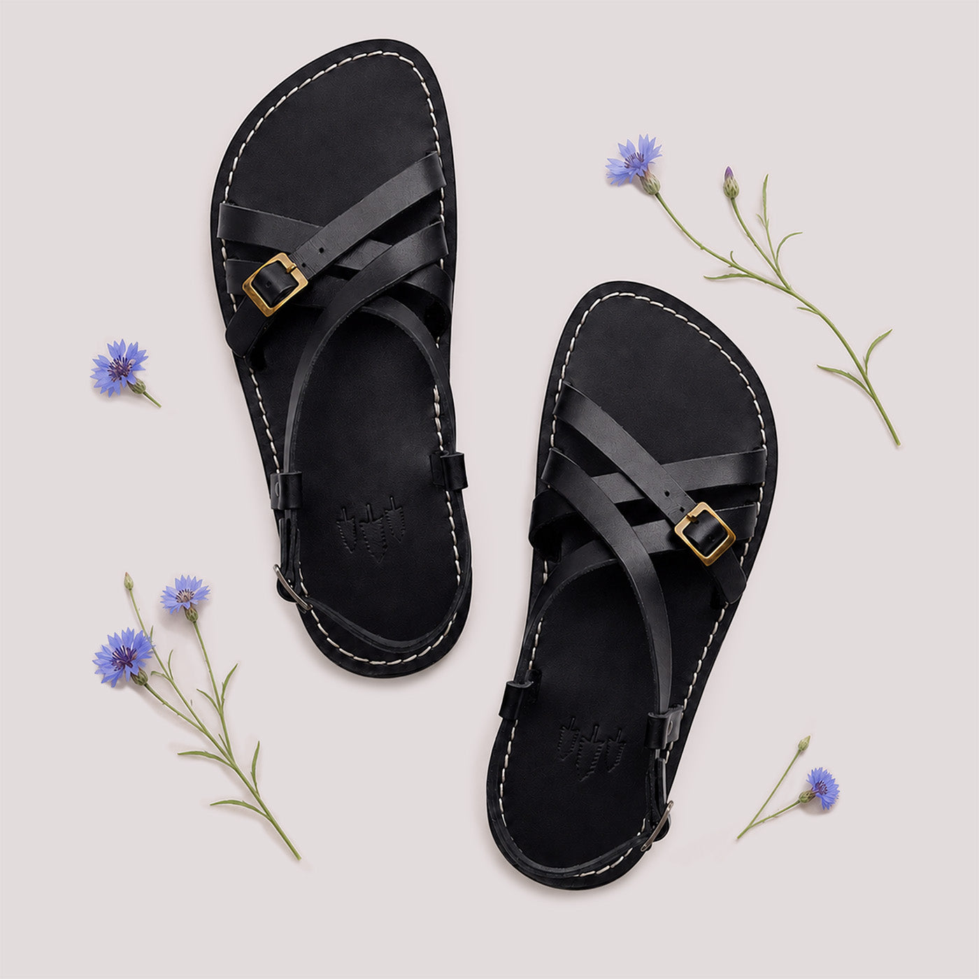 Nero | Person wearing strappy leather sandals with two buckle accents