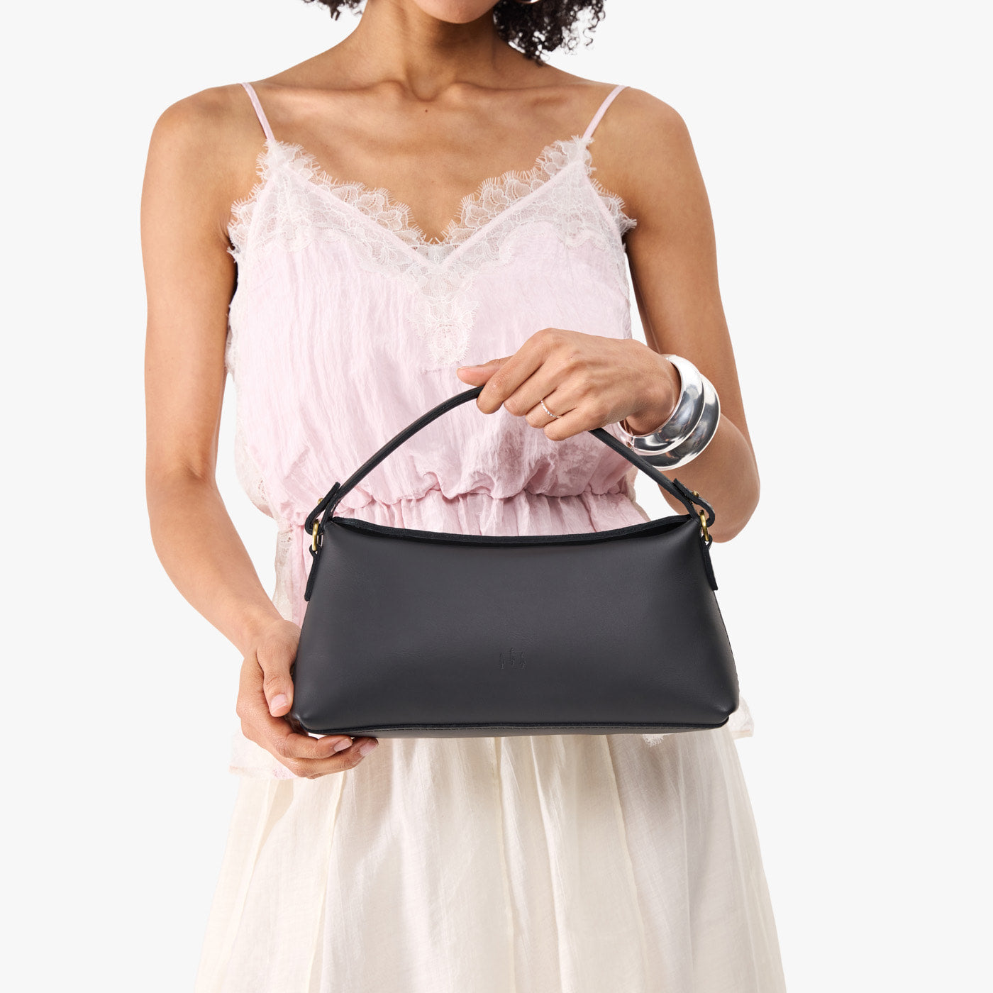Black | Model holding a black colored bowler style hand bag