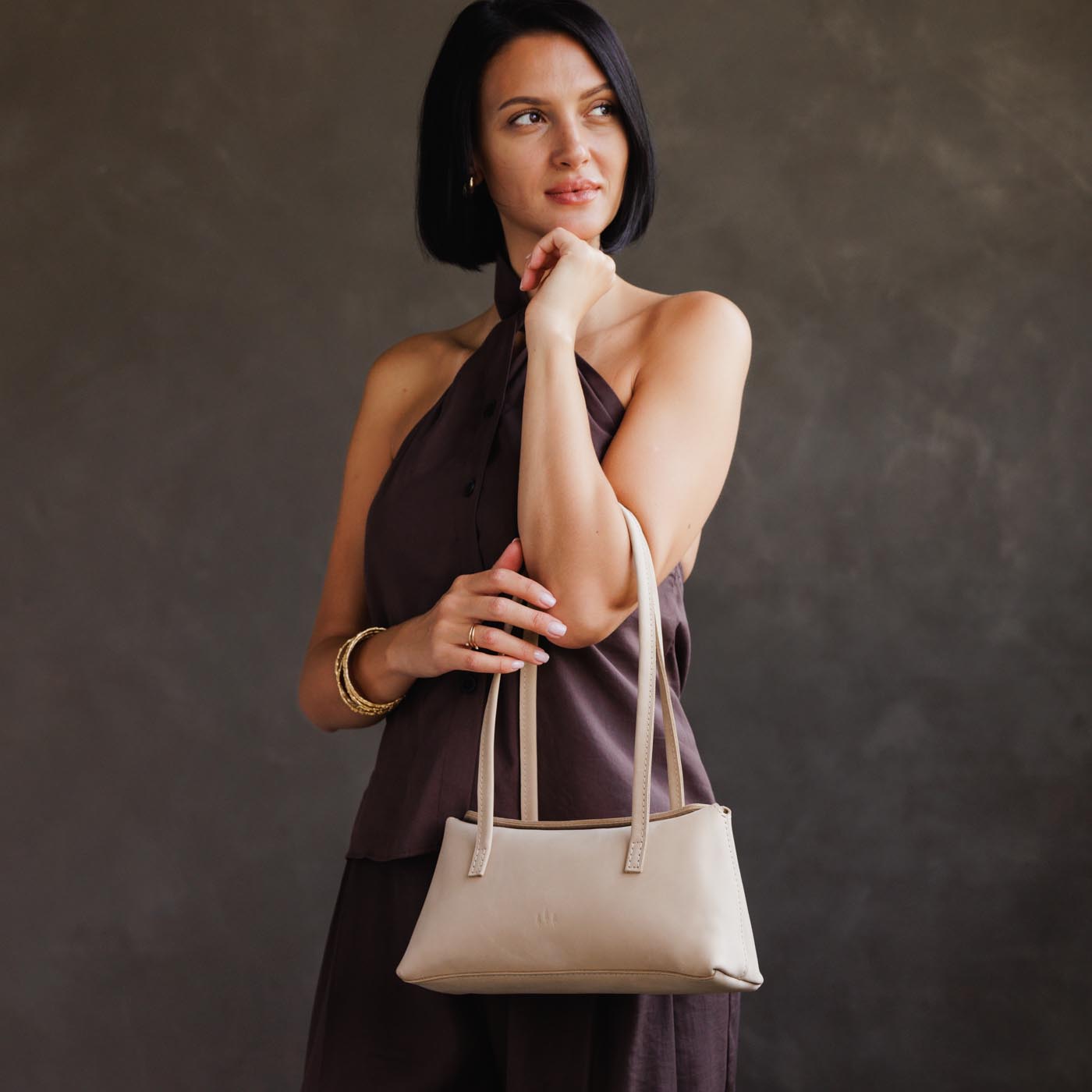Dragon Bone | Woman wearing a white leather bowler bag against a white background