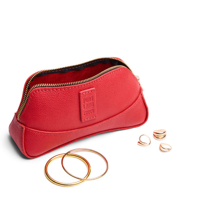 Cherry | Handmade leather makeup bag pouch with top zipper open next to gold jewelry