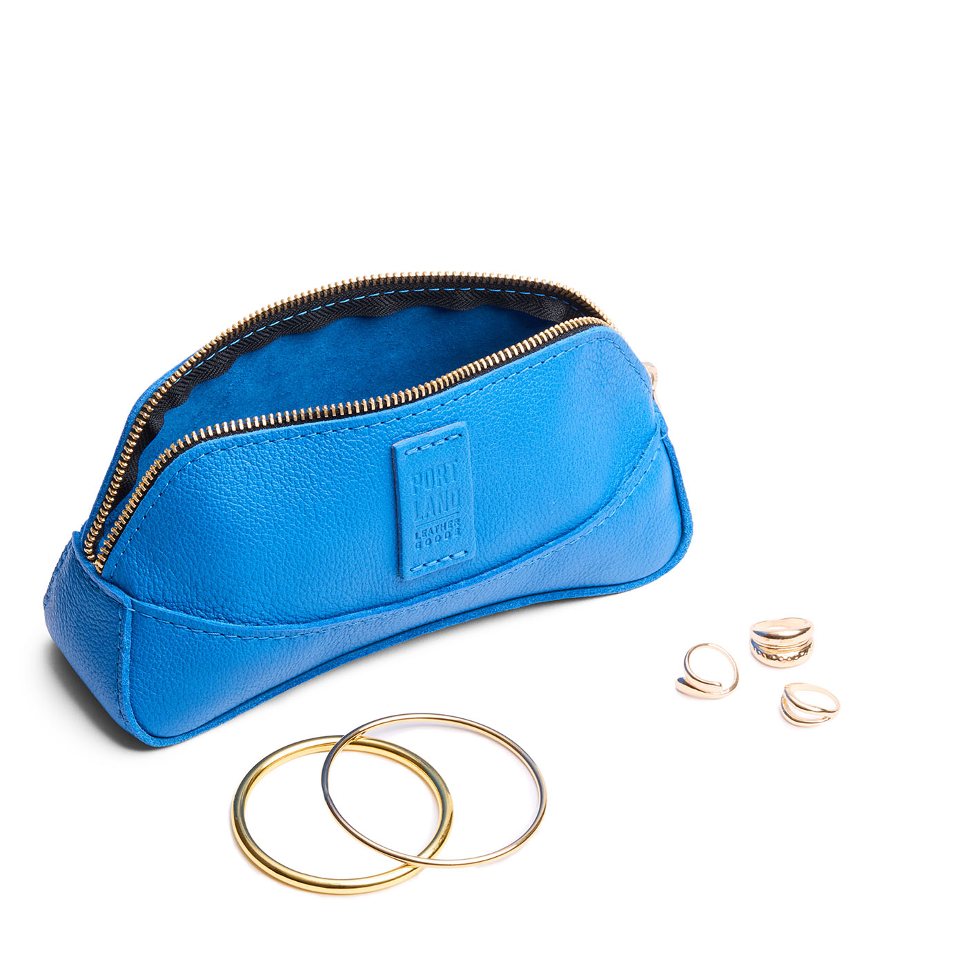 Skydive | Handmade leather makeup bag pouch with top zipper open next to gold jewelry