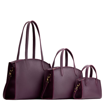 Plum | Size comparison image of Mini, Medium, and Large-sized leather tote bags with handles, adjustable crossbody strap, zipper top, and back pockets