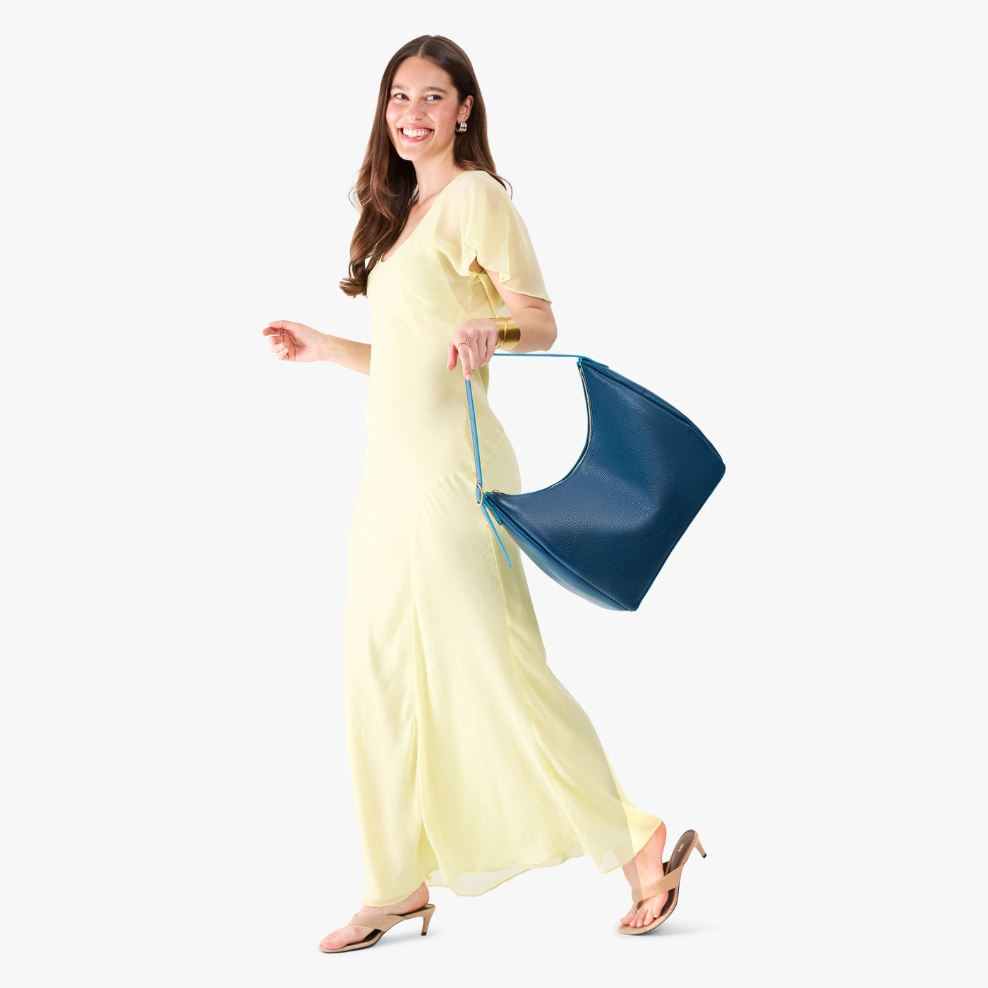 Caspian*Large | Model holding u-shaped, flat-bottomed leather shoulder bag with adjustable strap