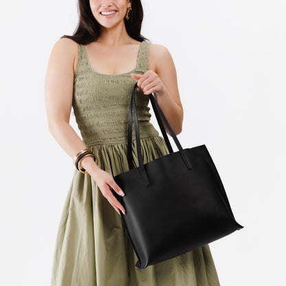 Black*Large | Model holding leather tote bag with interior snap key loop