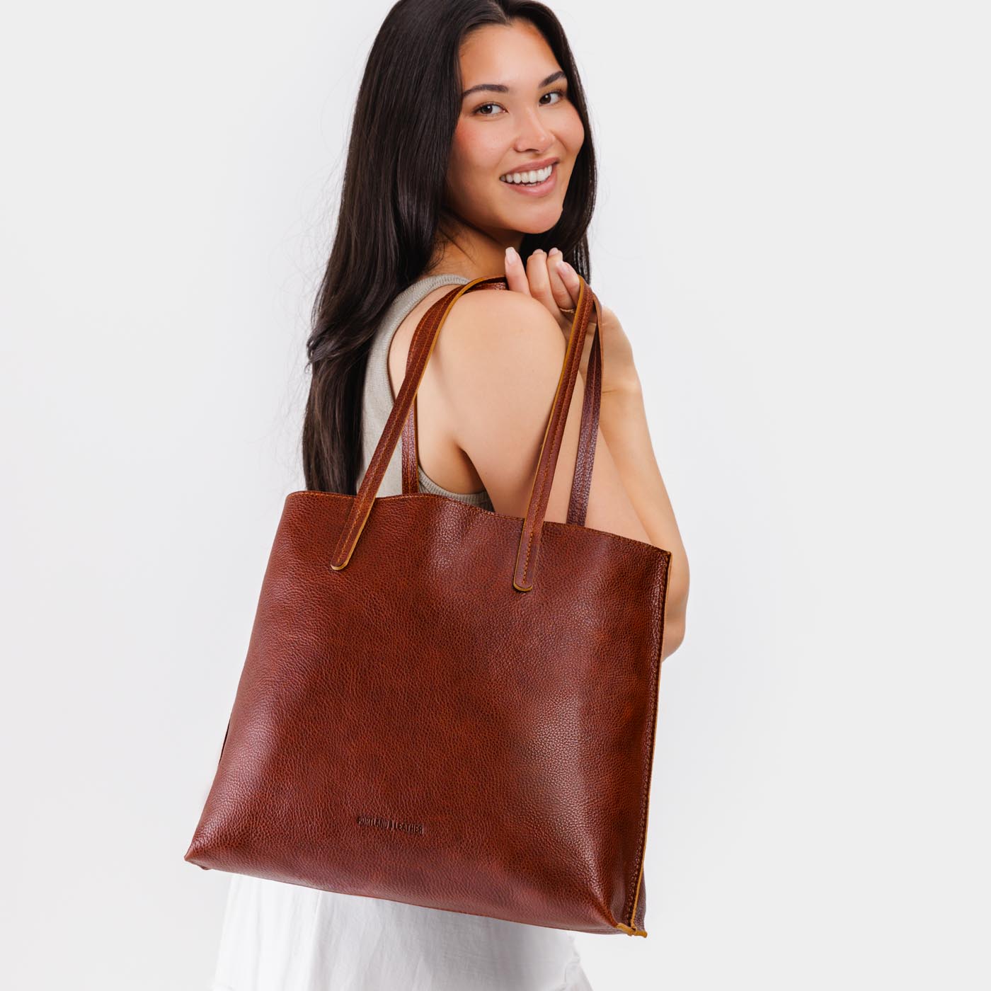 Nutmeg*Large | Model holding leather tote bag with interior snap key loop