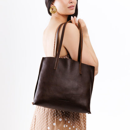 Coldbrew*Medium | Model holding leather tote bag with interior snap key loop