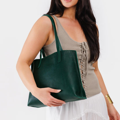 Forest Green*Medium | Model holding leather tote bag with interior snap key loop