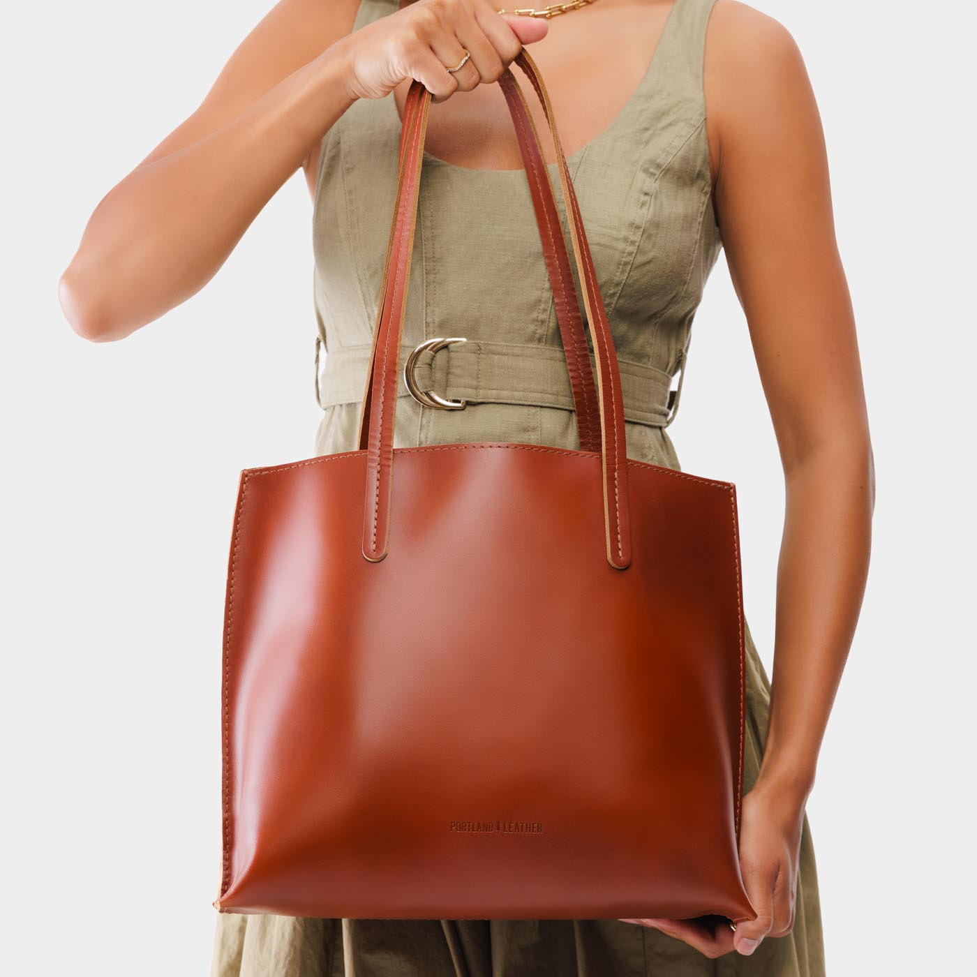 Madrone*Medium | Model holding leather tote bag with interior snap key loop