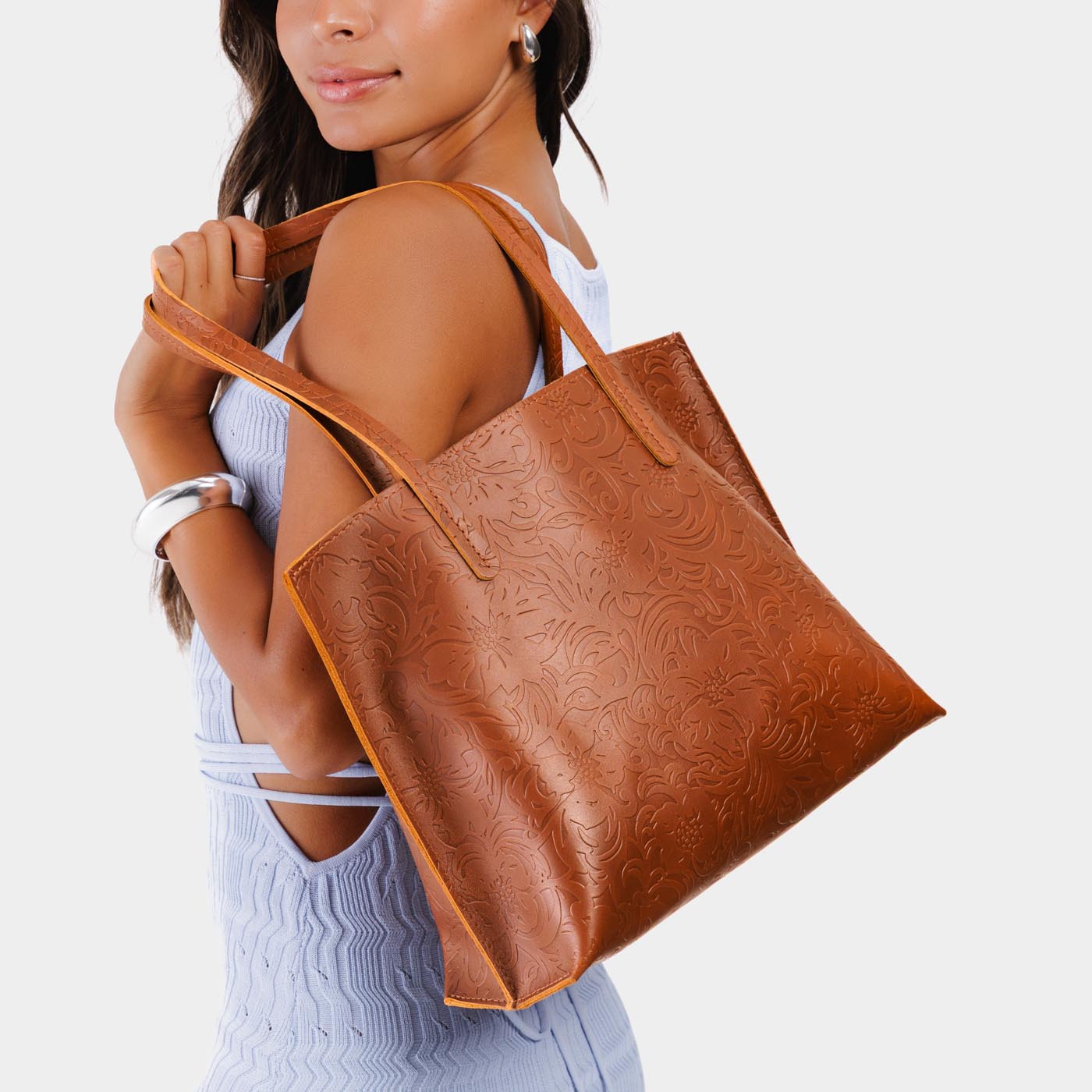 Meadow*Medium | Model holding leather tote bag with interior snap key loop