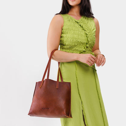 Nutmeg*Medium | Model holding leather tote bag with interior snap key loop