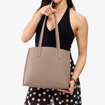 Stone*Medium | Model holding leather tote bag with matching leather handles