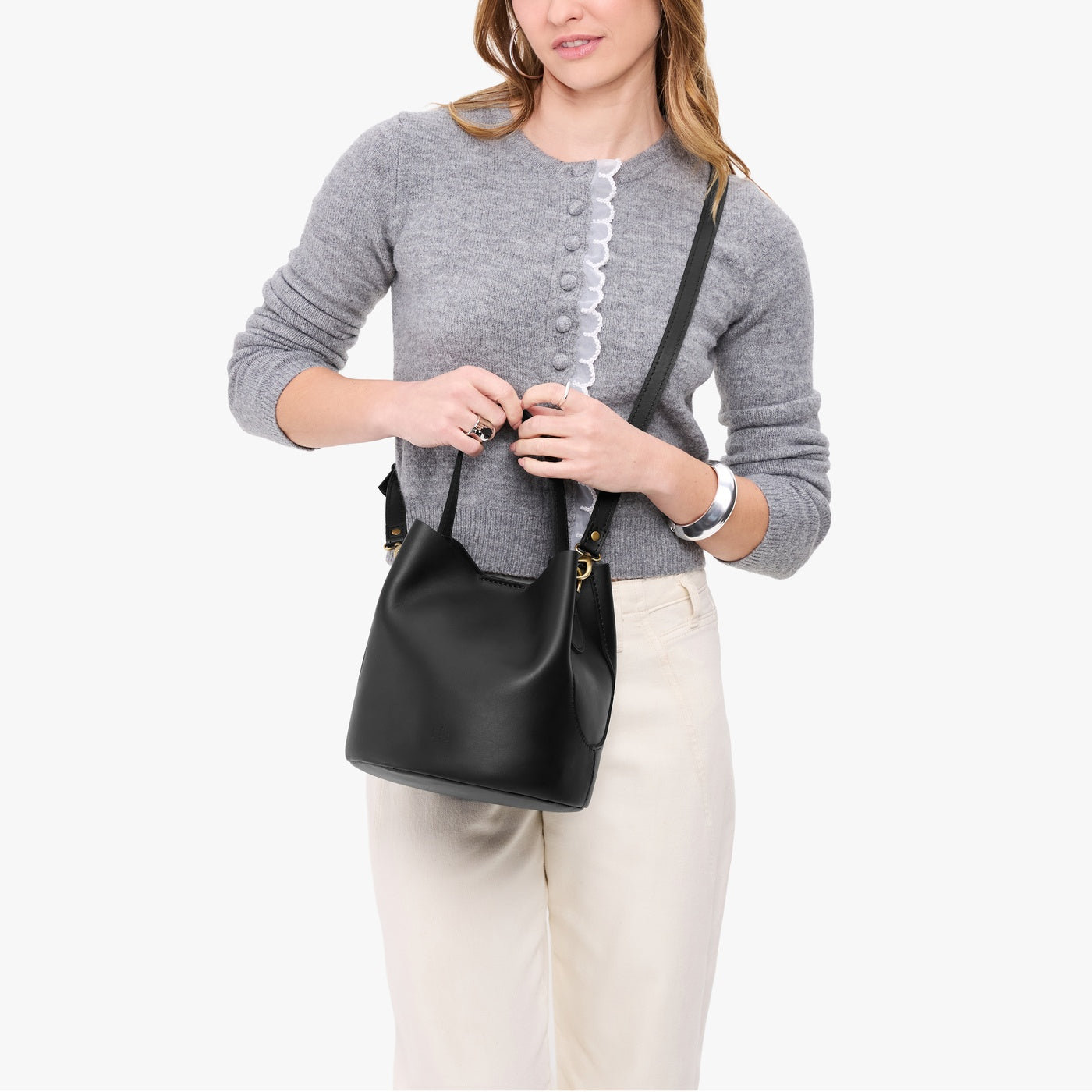 Black*Large | Model holding symmetrical bucket bag with handle, latch closure, and removable crossbody strap