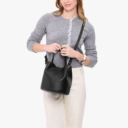 Black*Large | Model holding symmetrical bucket bag with handle, latch closure, and removable crossbody strap