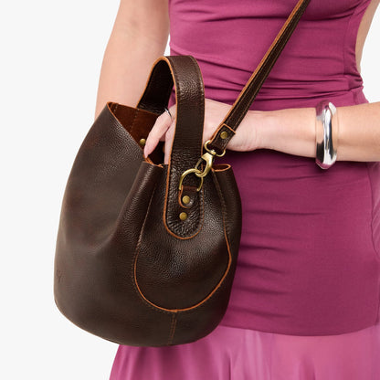 Coldbrew*Large | Model holding symmetrical bucket bag with handle, latch closure, and removable crossbody strap