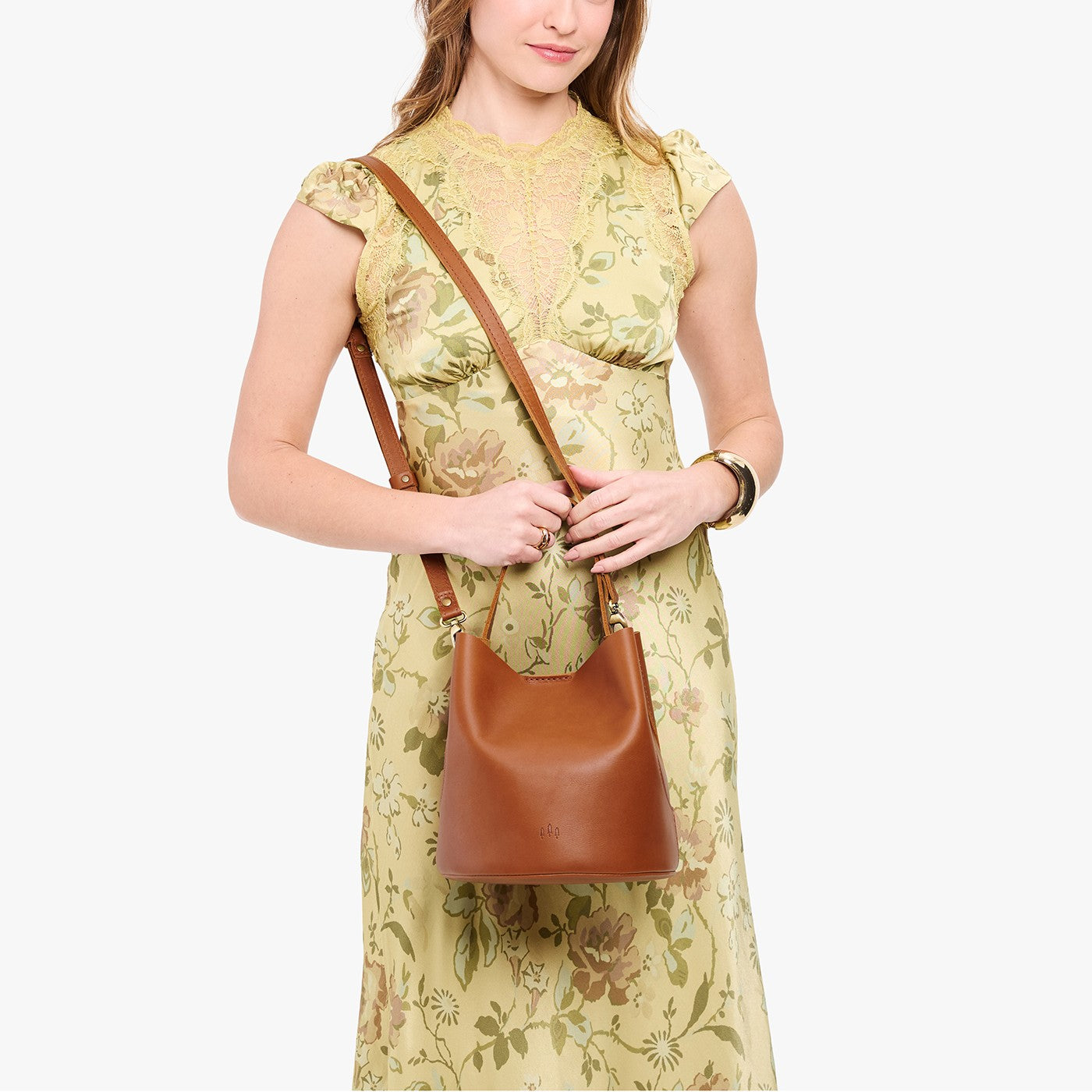 Honey*Large | Model wearing symmetrical bucket bag with handle, latch closure, and removable crossbody strap