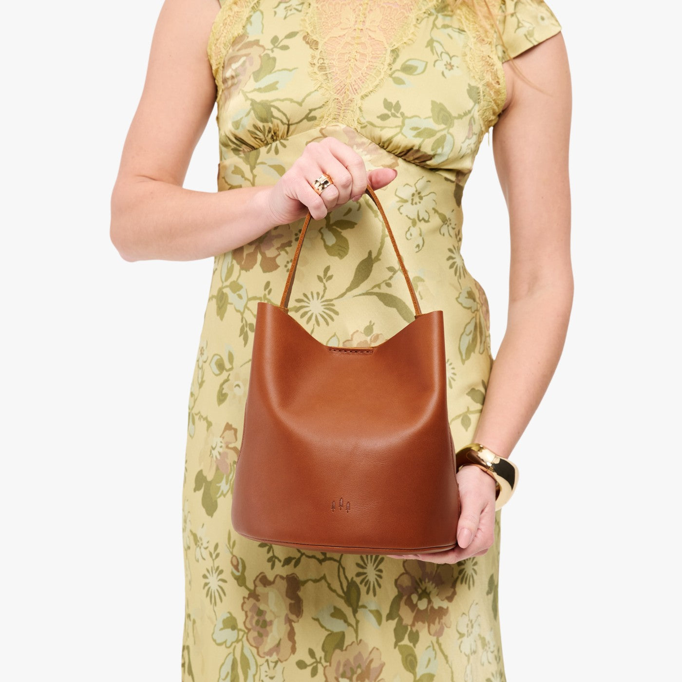 Honey*Large | Model holding symmetrical bucket bag with handle, latch closure, and removable crossbody strap
