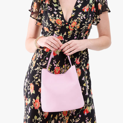Pinkaboo*Large | Model holding symmetrical bucket bag with handle, latch closure, and removable crossbody strap