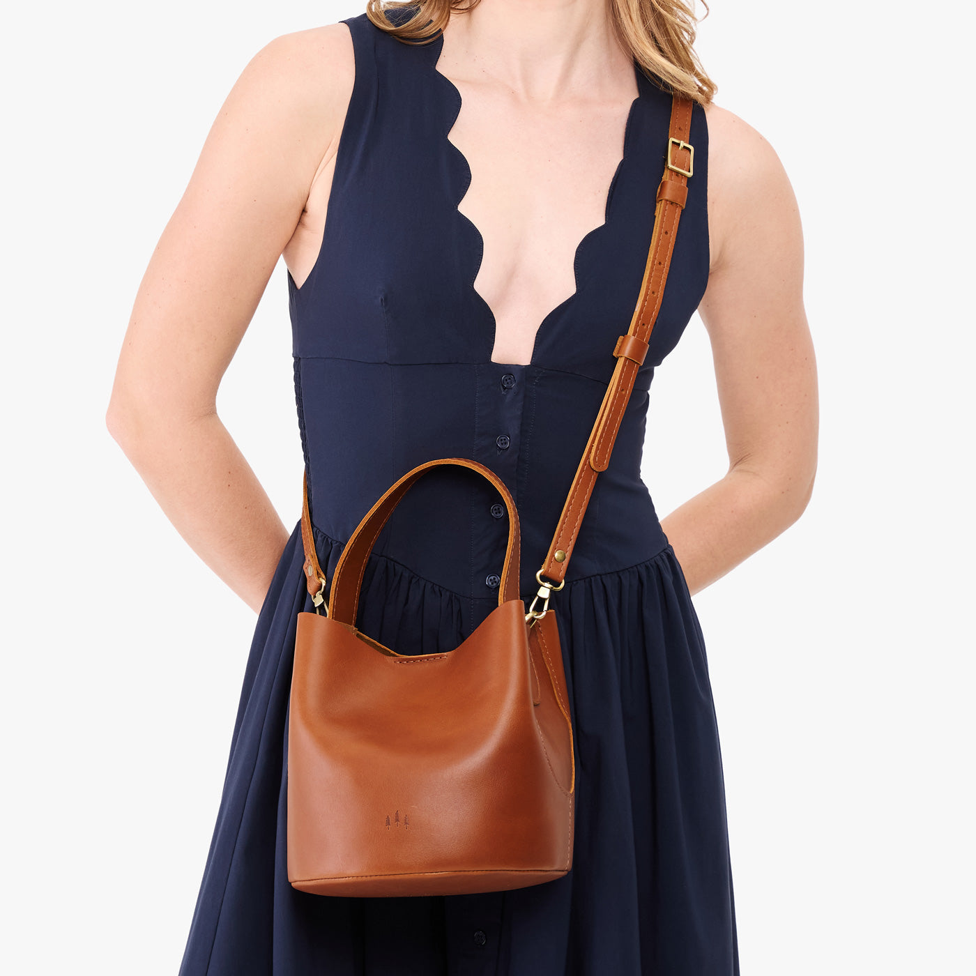 Honey*Small | Model wearing symmetrical bucket bag with handle, latch closure, and removable crossbody strap