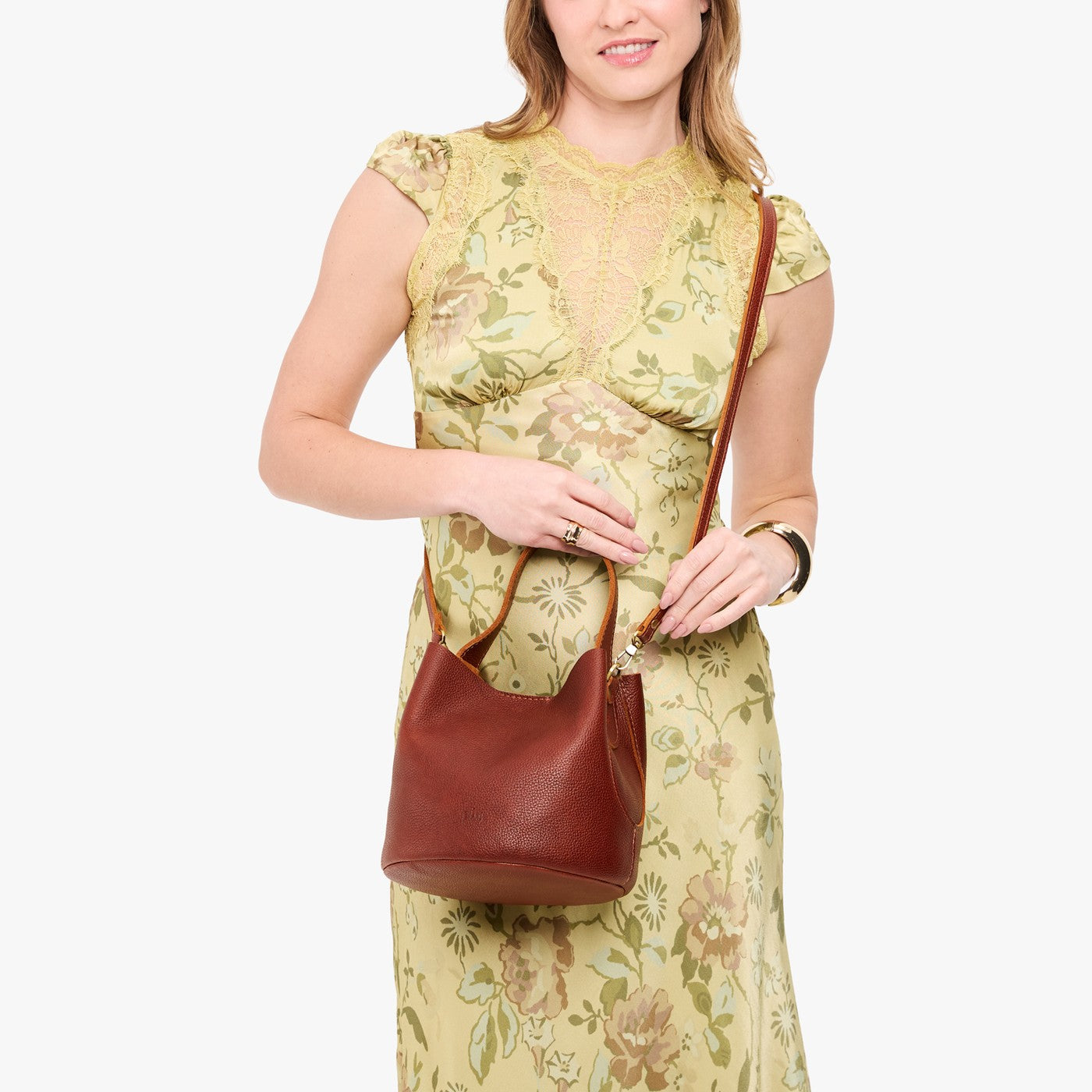 Nutmeg*Small | Model wearing symmetrical bucket bag with handle, latch closure, and removable crossbody strap