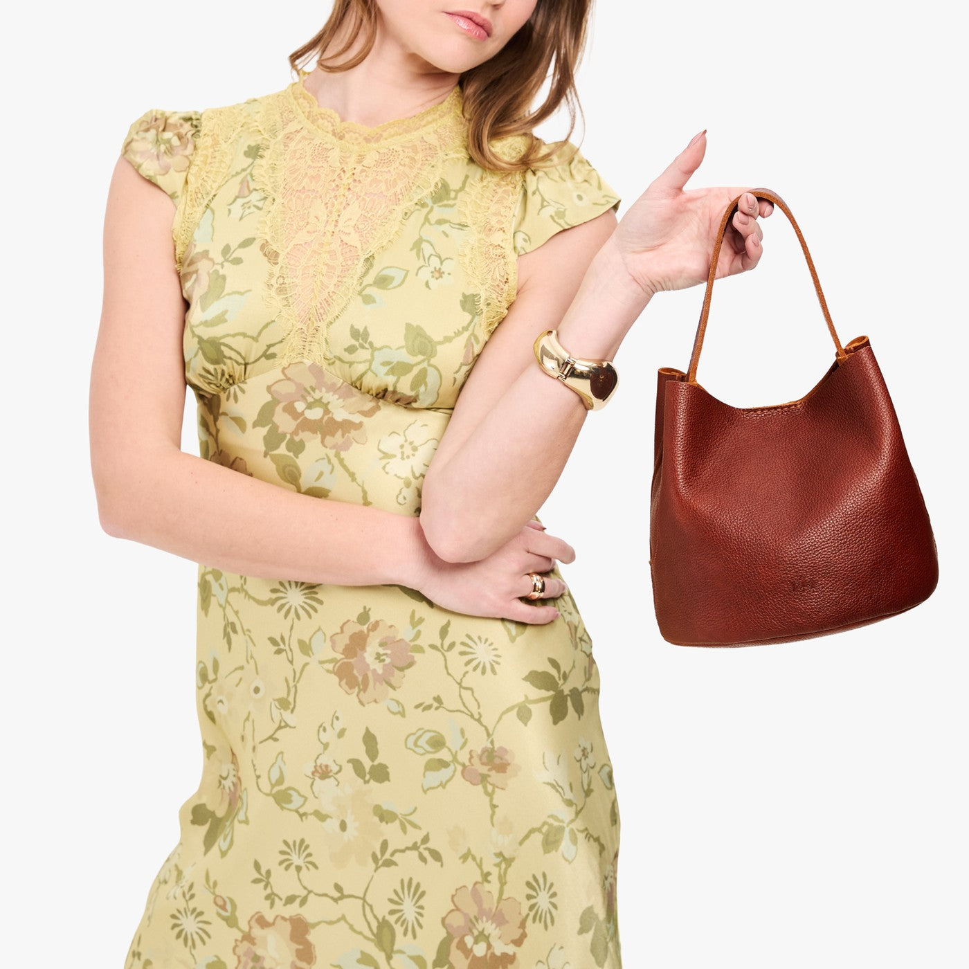 Nutmeg*Small | Model holding symmetrical bucket bag with handle, latch closure, and removable crossbody strap
