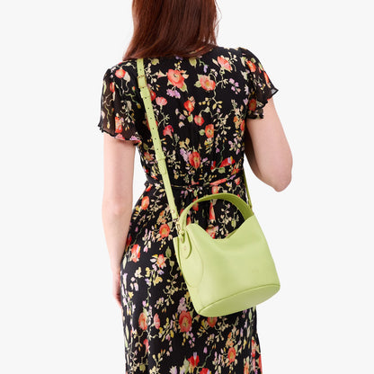 Shadow Lime*Small | Model wearing symmetrical bucket bag with handle, latch closure, and removable crossbody strap