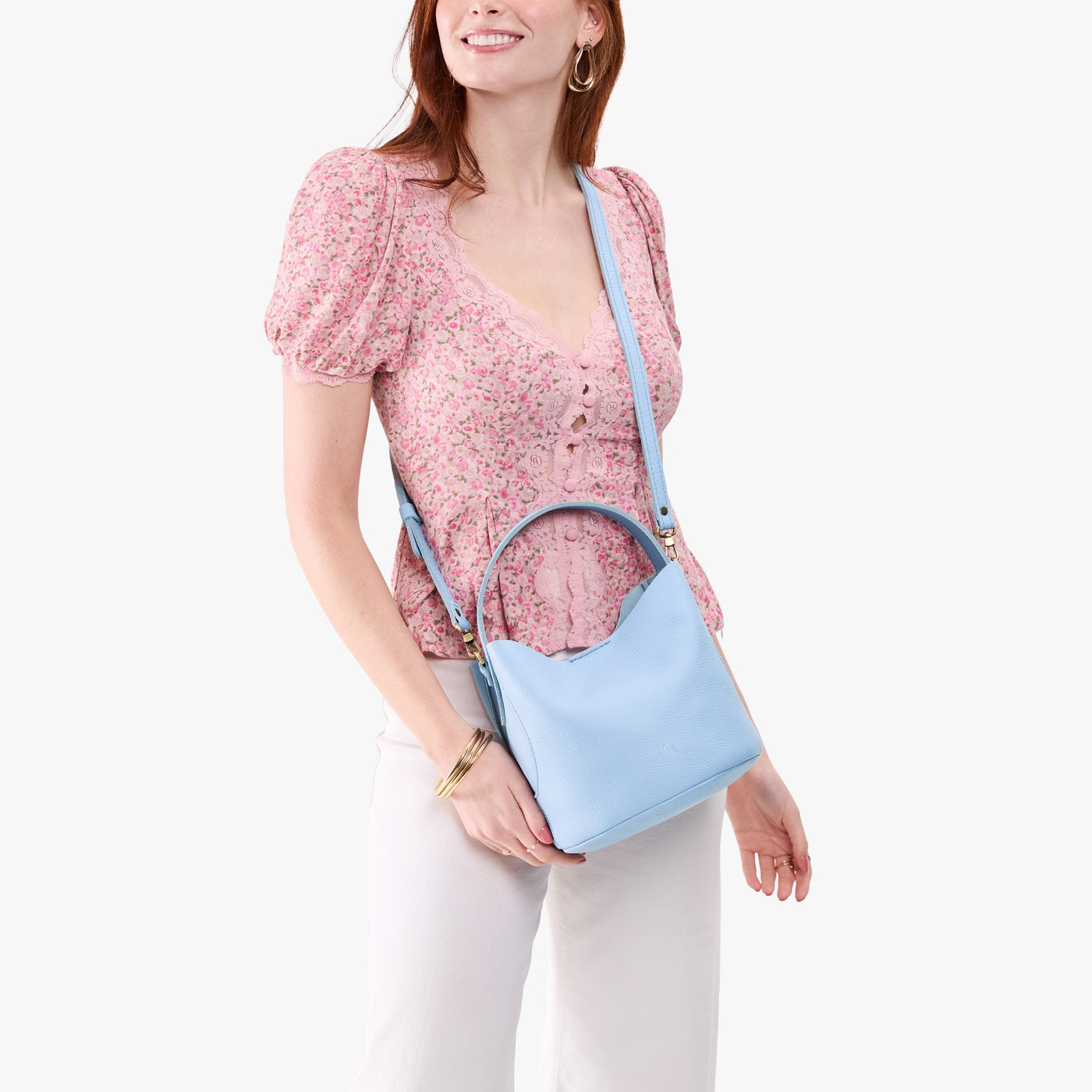 Skyway*Small | Model wearing symmetrical bucket bag with handle, latch closure, and removable crossbody strap