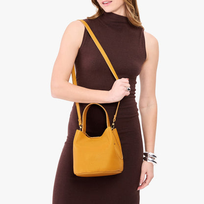 Sunshine*Small | Model wearing symmetrical bucket bag with handle, latch closure, and removable crossbody strap