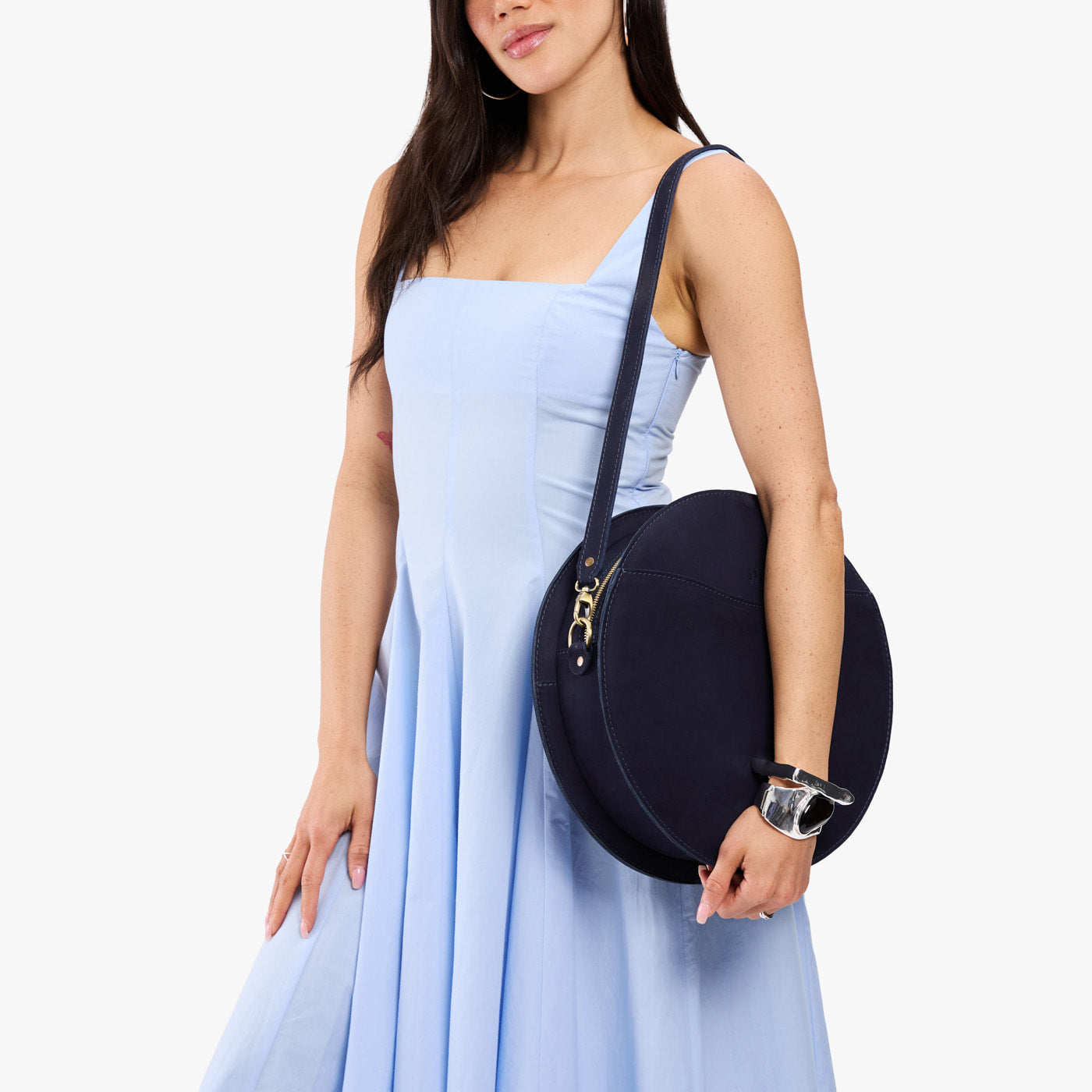 Velvet Blue | Model carrying large circle shaped leather bag with top zipper and carrying strap