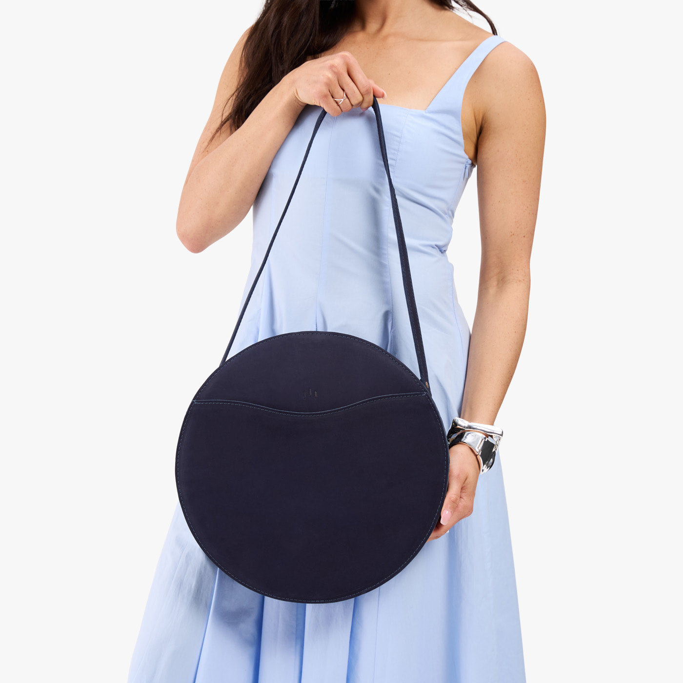 Velvet Blue | Model carrying large circle shaped leather bag with top zipper and carrying strap