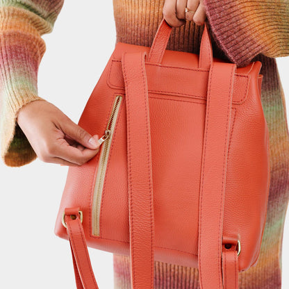 Coral | Model wearing a leather backpack on a white background