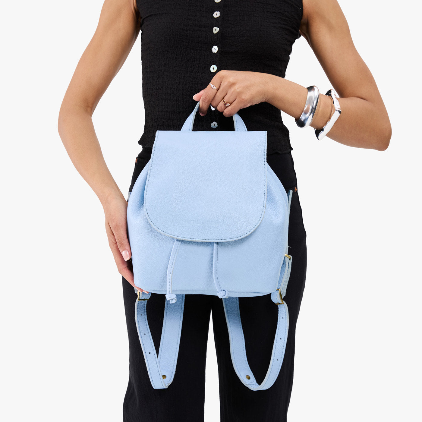 Skyway | Pebbled leather drawstring backpack being held by a person