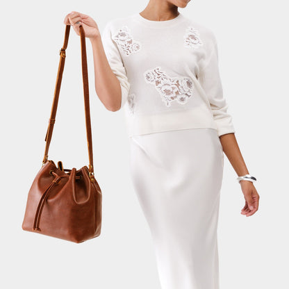 Nutmeg*Large | Model holding slouchy crossbody bag with drawstring closure