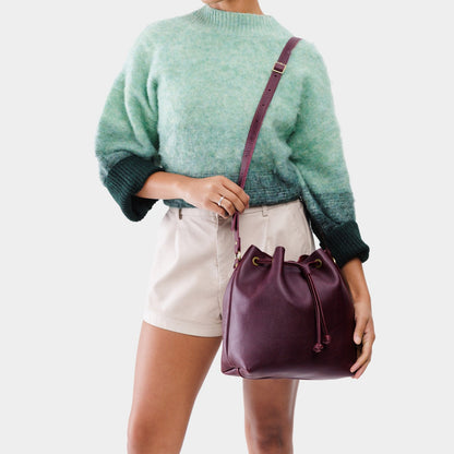 Plum*Large | Model holding slouchy crossbody bag with drawstring closure