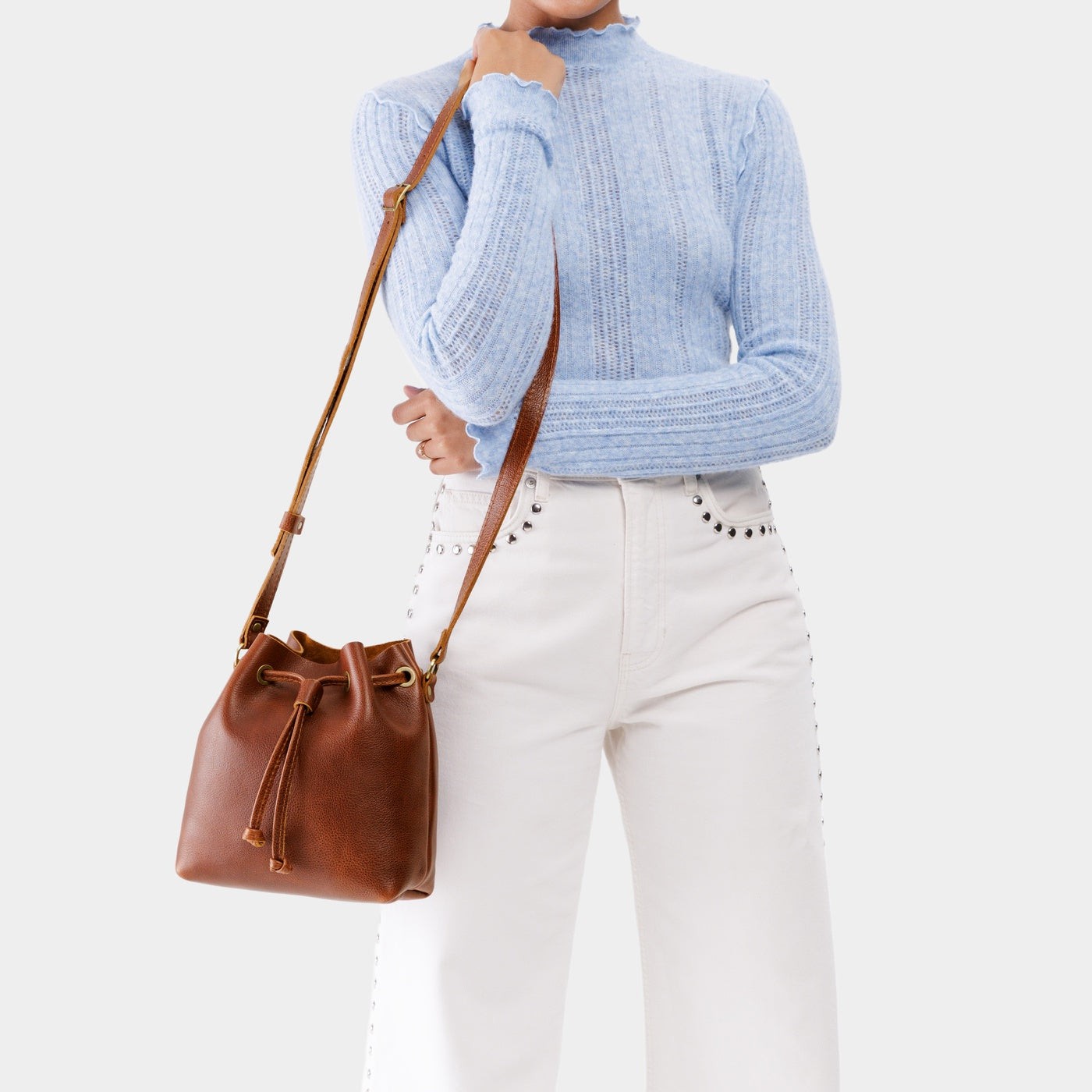 Nutmeg*Small | Model holding slouchy crossbody bag with drawstring closure