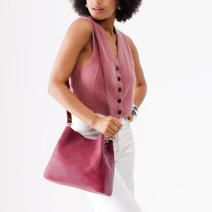 Anemone | Model wearing symmetrical bucket bag with latch closure and removable crossbody strap
