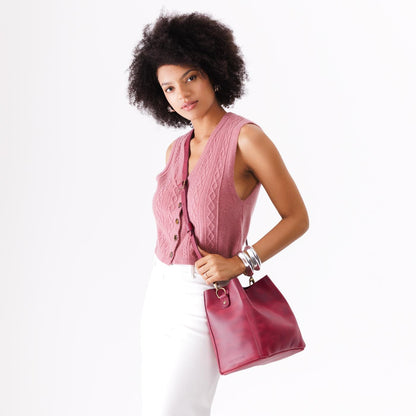 Anemone | Model wearing symmetrical bucket bag with latch closure and removable crossbody strap