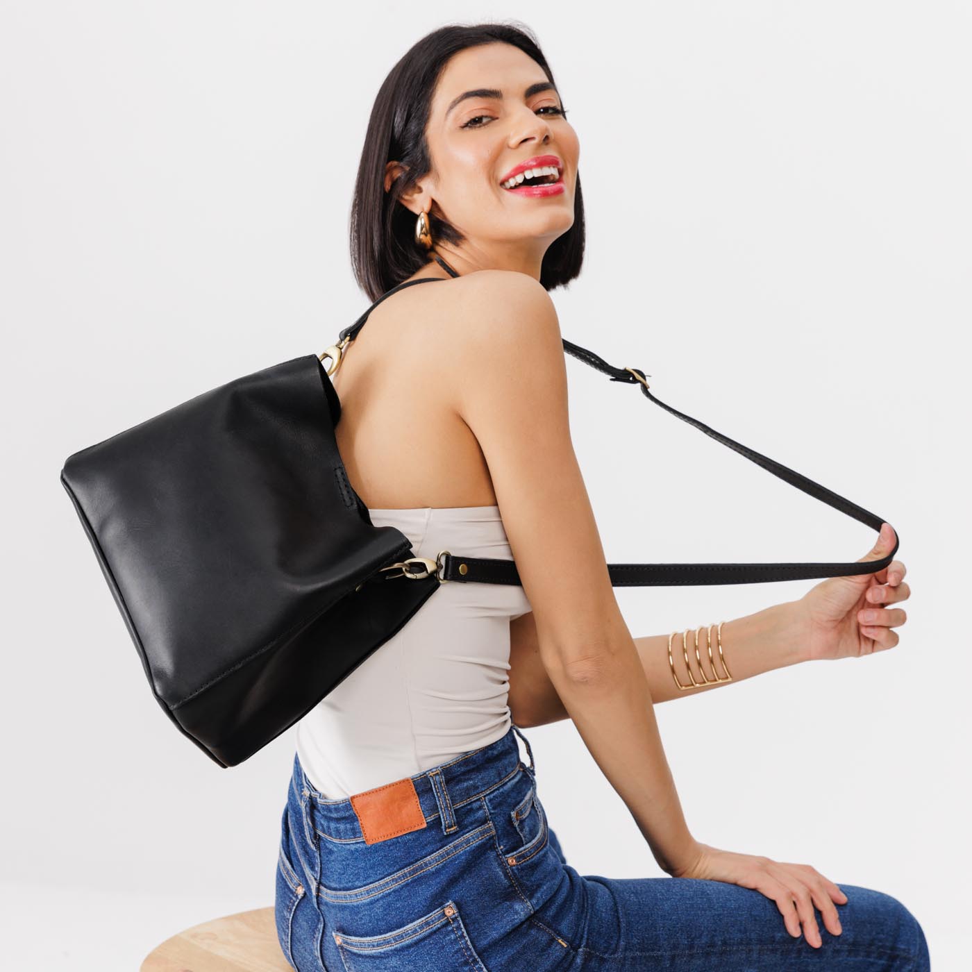 Black | symmetrical bucket bag with latch closure and removable crossbody strap
