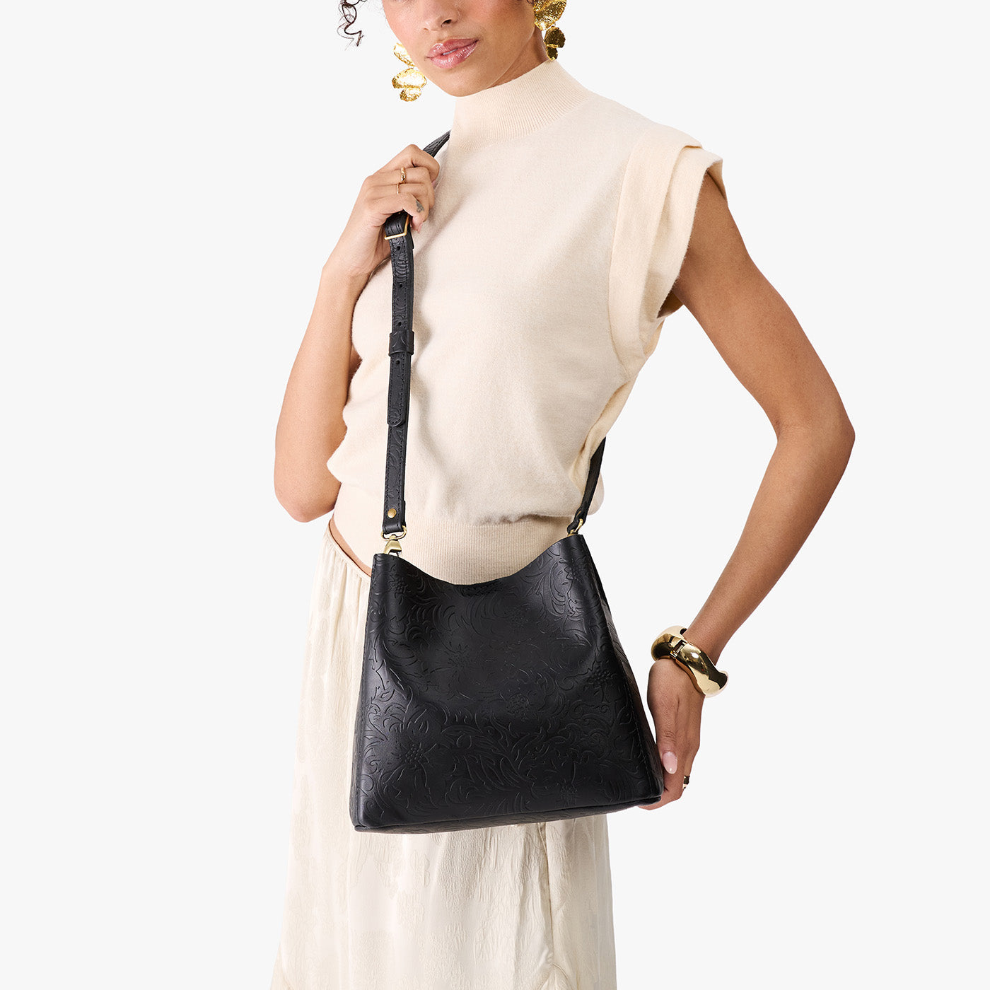 Dahlia | Model wearing symmetrical bucket bag with latch closure and removable crossbody strap