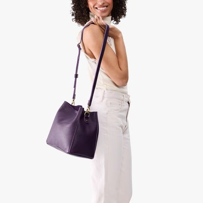 Empire | Model wearing symmetrical bucket bag with latch closure and removable crossbody strap