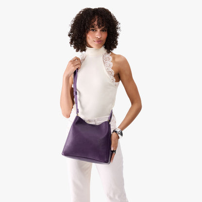 Empire | Model wearing symmetrical bucket bag with latch closure and removable crossbody strap