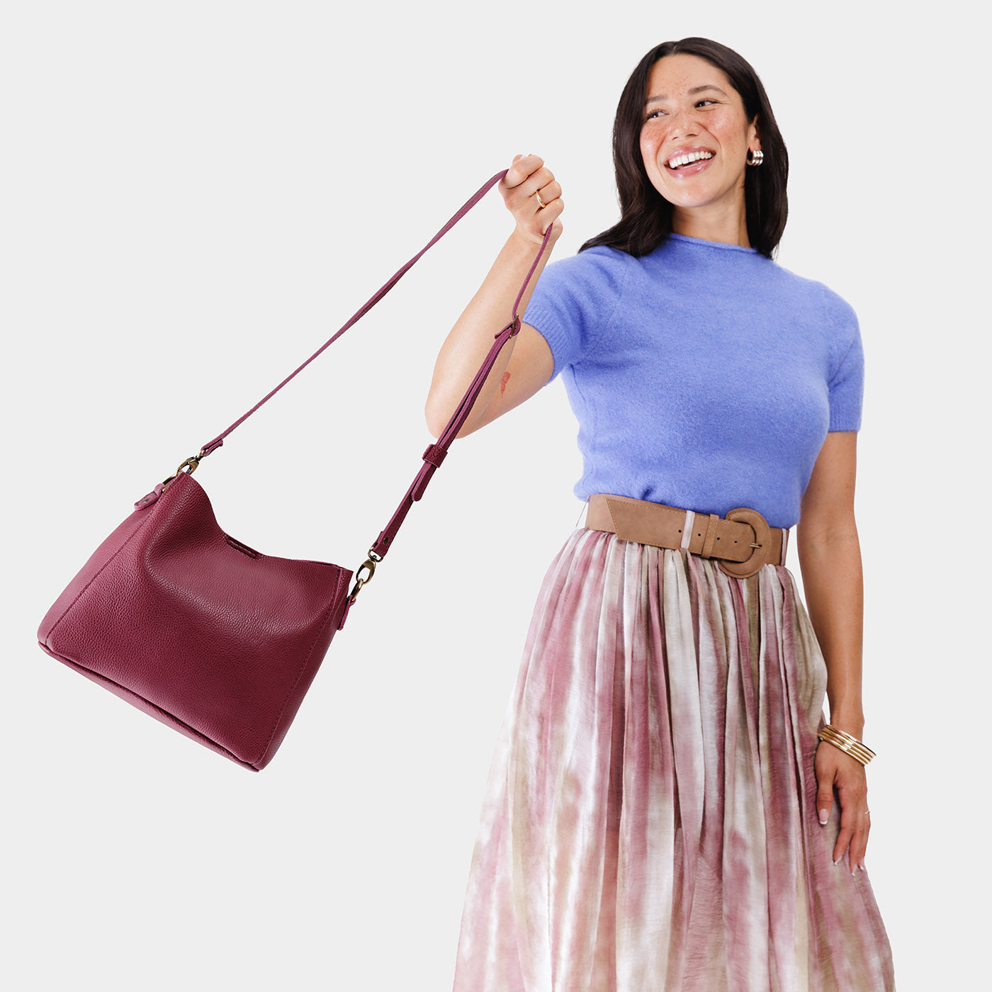 Orchid | Model holding symmetrical bucket bag with latch closure and removable crossbody strap