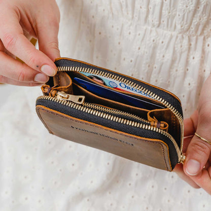 Canyon | Model holding small leather wallet with zipper open