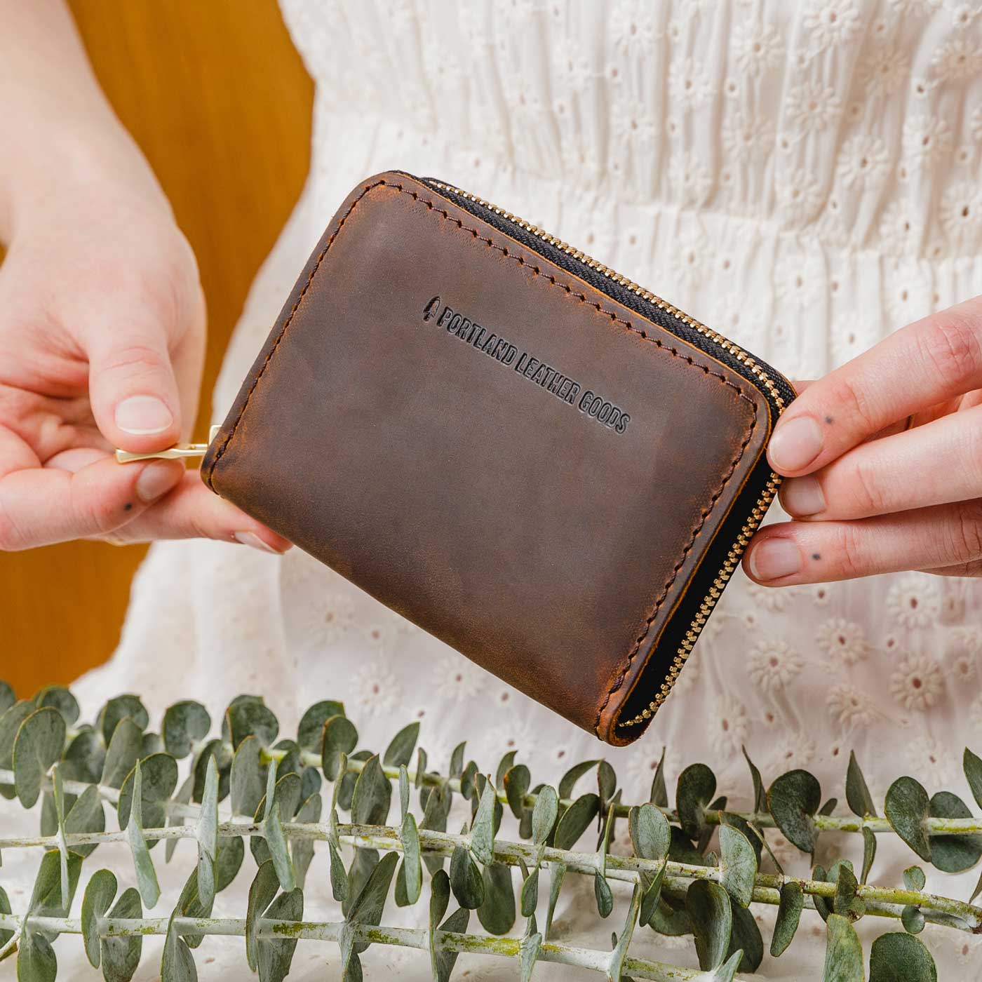 Canyon | Model holding small leather wallet with zipper closed